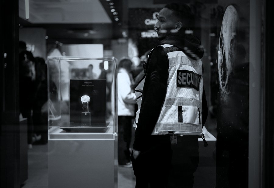 Uniformed security officer standing with arms crossed at a building entrance